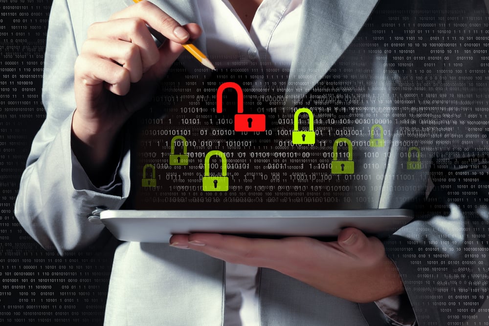 female business owner pointing to security lock icon on a laptop computer, cybersecurity protection for business