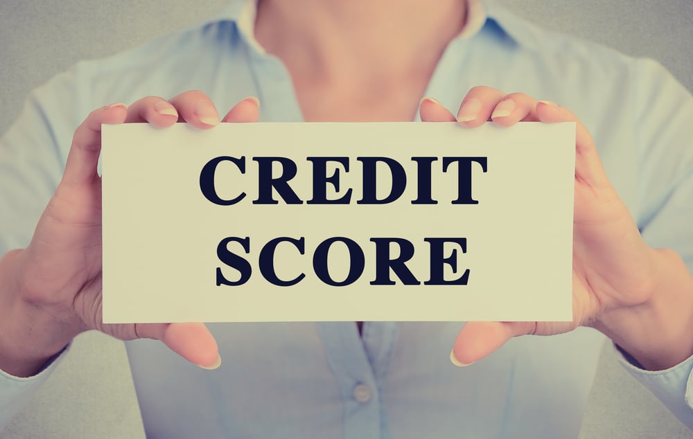 female business owner holding sign that reads credit score, how to improve your business credit score