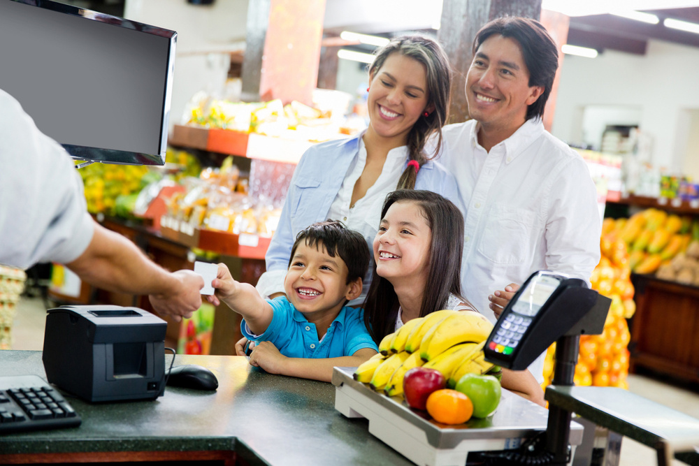 family smiling at the supermarket checkout stand, retail equipment financing