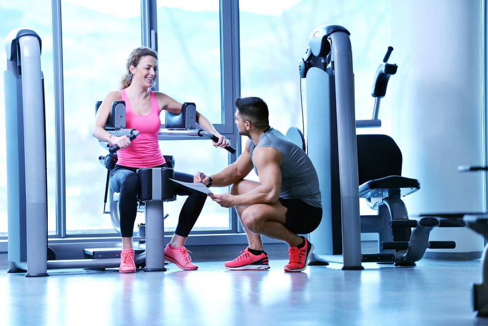personal trainer with woman in a modern fitness center, fitness equipment financing