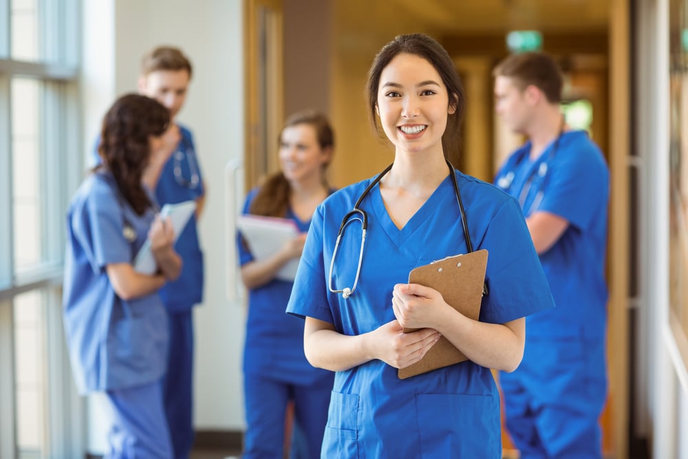 female medical professional with team in background, healthcare practice financing