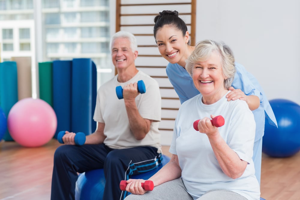 personal trainer in gym with senior couple, business line of credit for fitness centers