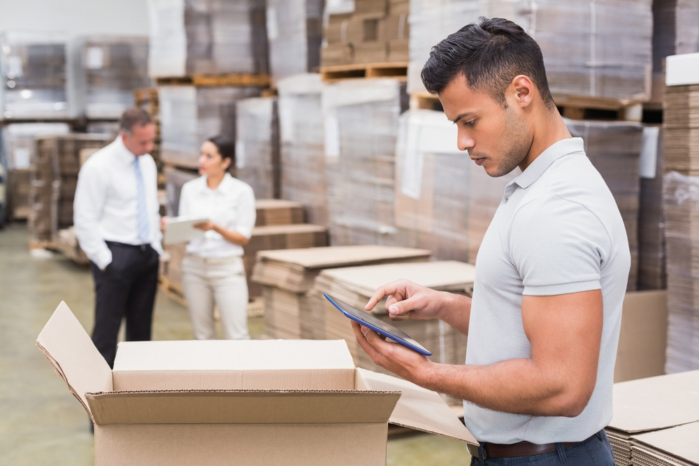 warehouse manager checking inventory on a tablet, business software financing and leasing