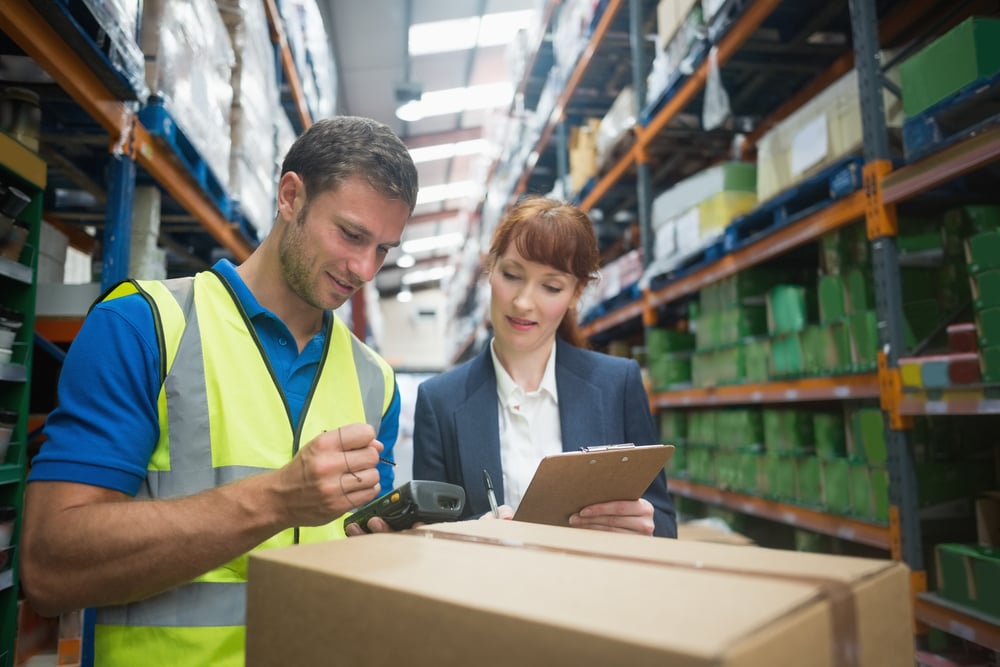 two wholesale distributor workers calculating the cost of a customer's order
