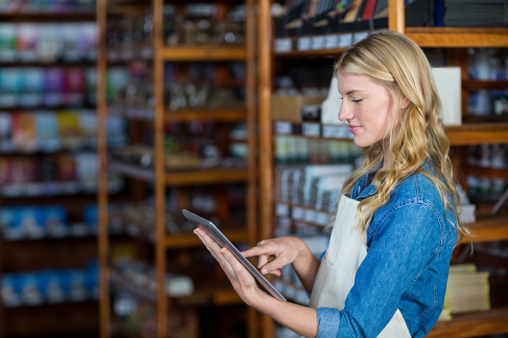 female grocery store owner using digital tablet
