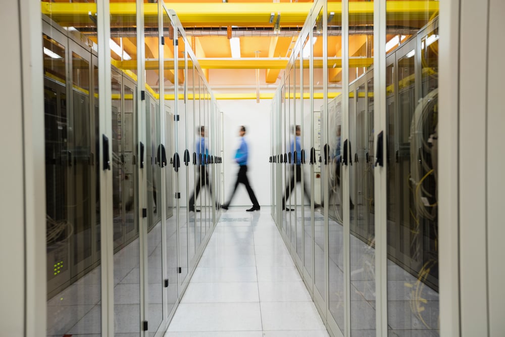 technician walking in hallway of server room