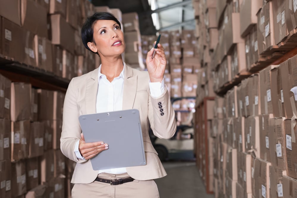 wholesale distribution manager checking her inventory in a large warehouse