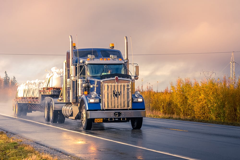 large blue truck hauling freight on the open road