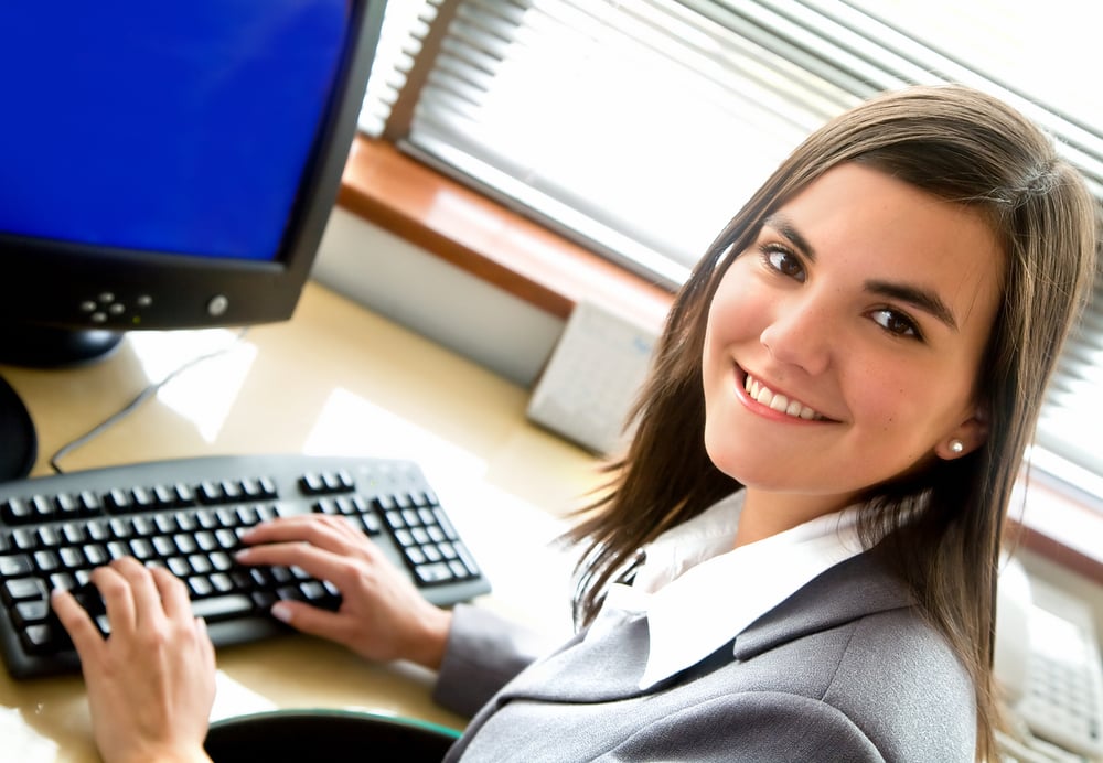 happy businesswoman smiling while working on computer