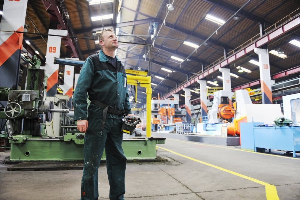 A manufacturing professional admiring the size and scope of a large manufacturing facility.