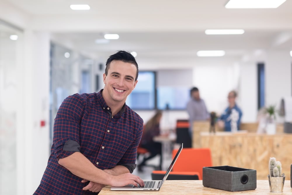 portrait of young businessman in casual clothes at modern  startup business office space, working on laptop computer