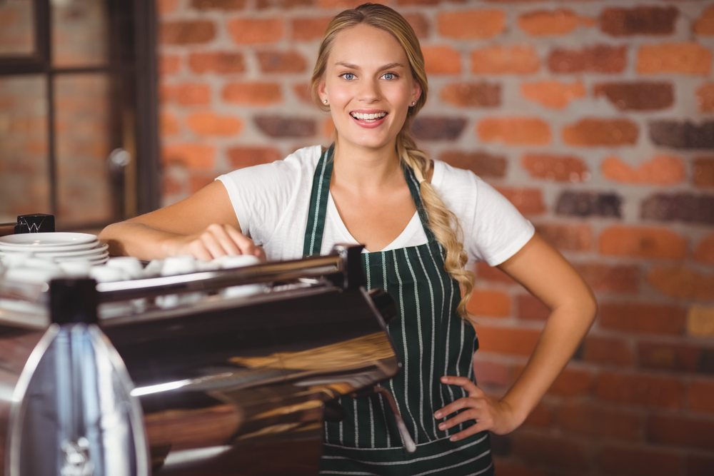 female coffee shop franchise owner smiling, how to fund your franchise