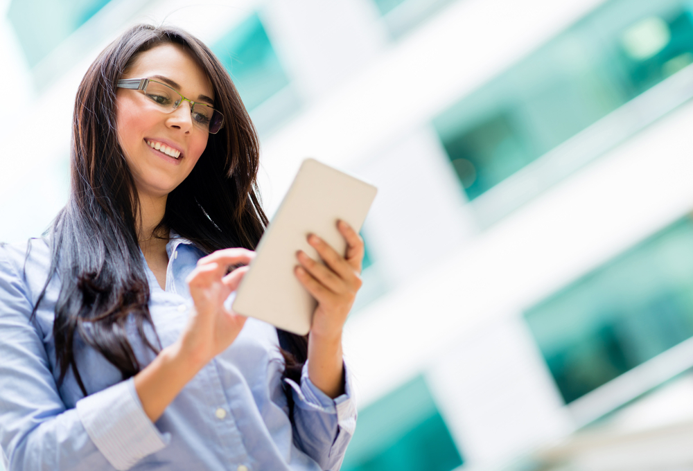 female business owner smiling while using mobile tablet, five ways to manage cash flow