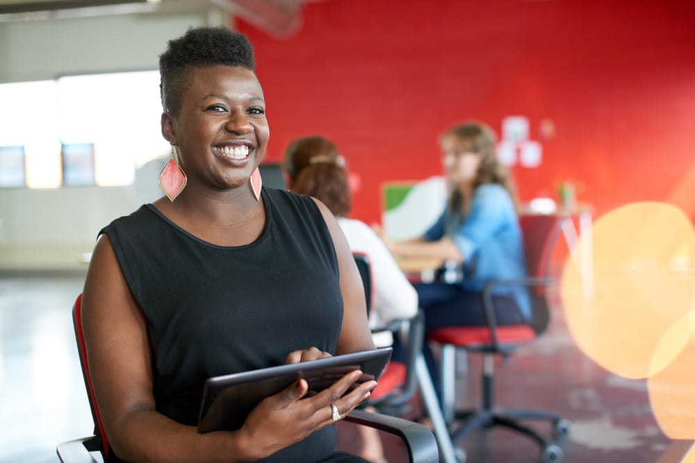 female business owner smiling in office, mid-year business checklist