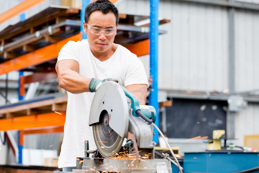 machinery worker using a large saw, six benefits of equipment financing